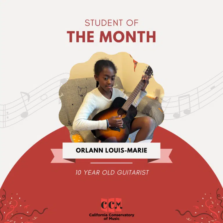 Orlann playing guitar with student of the month title