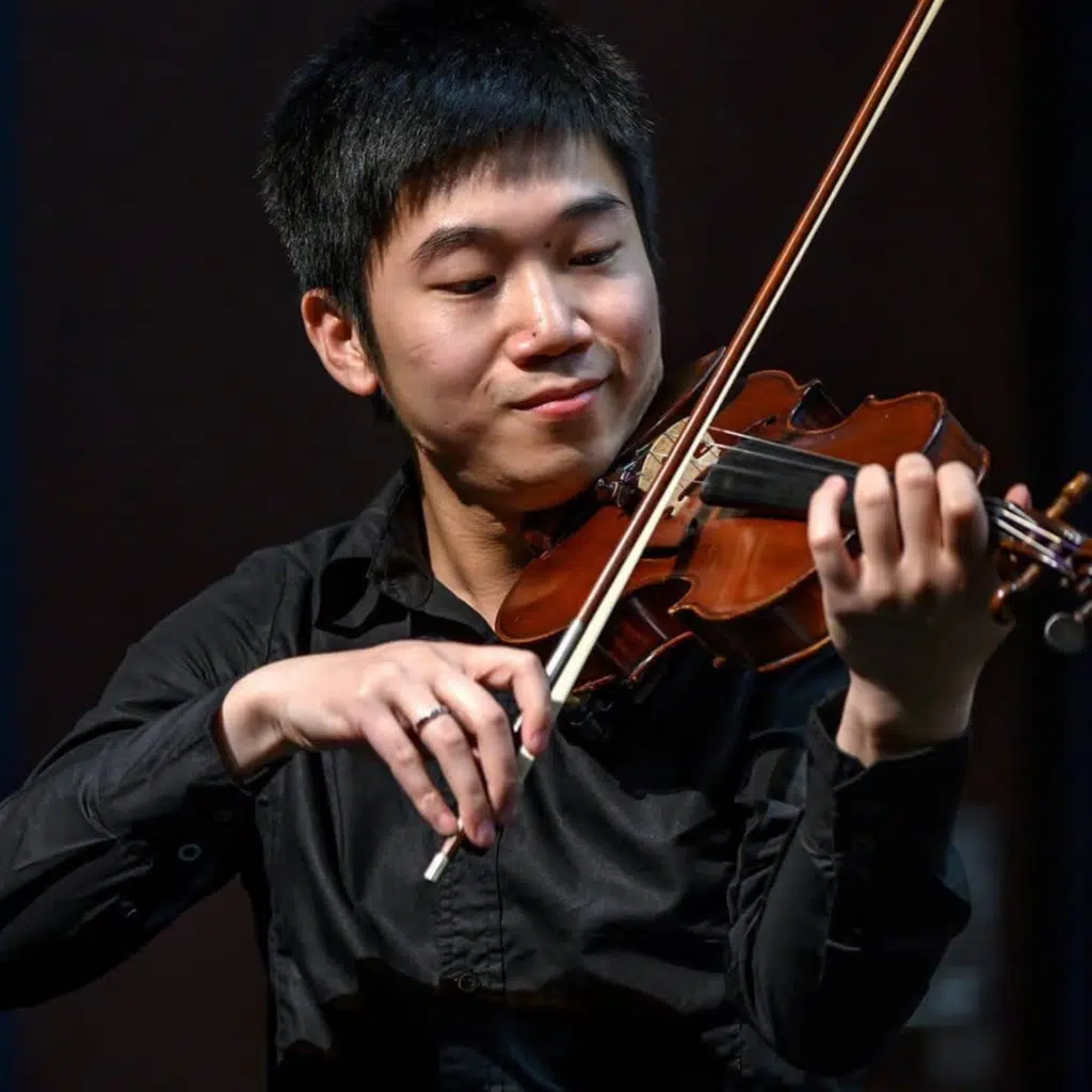 Junhong playing violin with slight smile